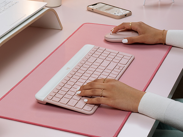 a woman using mk470 slim wireless mouse and keyboard pink combo, desk mat large mouse dark rose pad