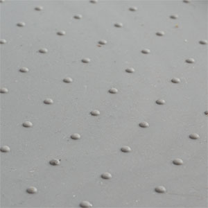 Close-up of a light gray textured surface with small, evenly spaced circular indentations or dimples.