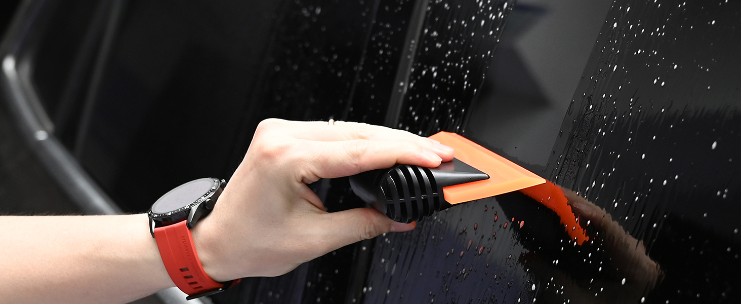 a person cleaning a window with a vacuum cleaner.