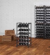 Black metal wine rack holding 24 red wine bottles in brick room and hardwood floor