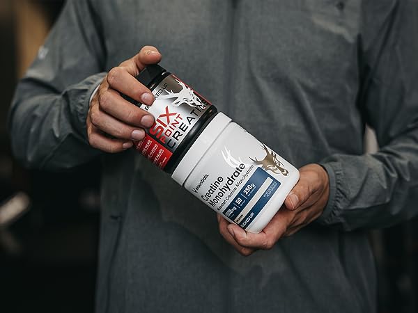 Person holding Bucked Up Creatine Monohydrate and 6 Point containers