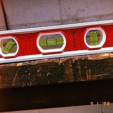 the same torpedo Level rests on an old wood log showing durability