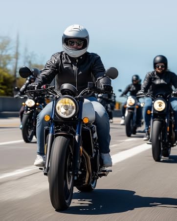 Motorcyclist in black leather jacket and white helmet rides dark-colored motorcycle on road. Two other riders visible in background. Bike features round headlight and yellow turn signals.