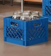 Blue plastic milk crate holding four mason jars
