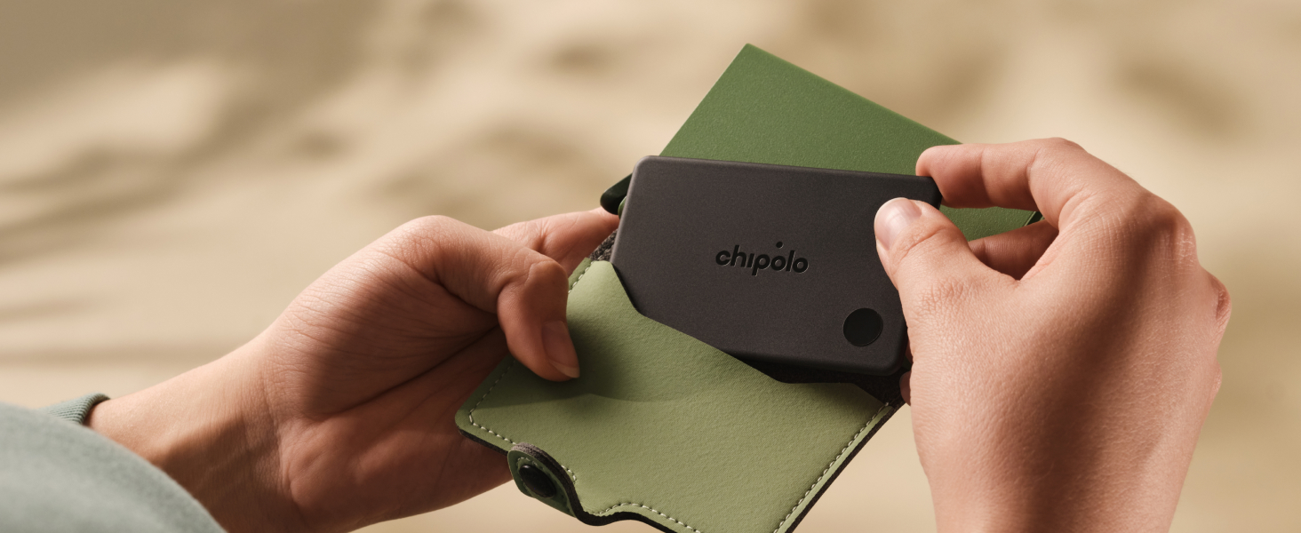Hands holding dark brown and olive-green fabric or material samples against neutral beige surface, demonstrating texture and color comparison.