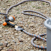 Man cleaning sidewalk using HydroTech hose and nozzle
