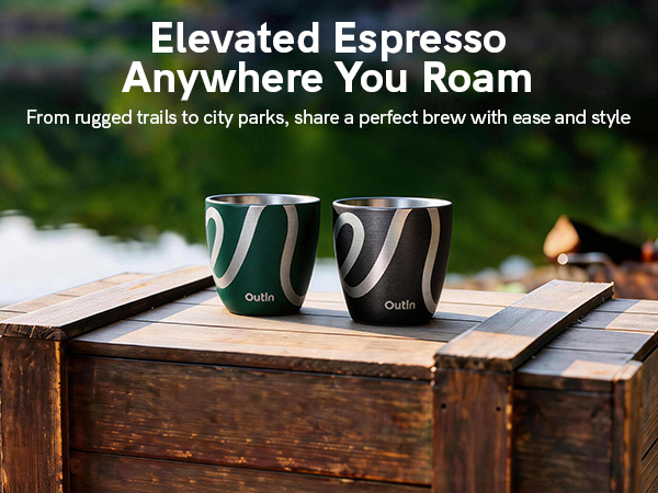 Text reads 'Elevated Espresso Anywhere You Roam' and 'From rugged trails to city parks, share a perfect brew with ease and style.' Two dark green insulated espresso cups on wooden surface outdoors.