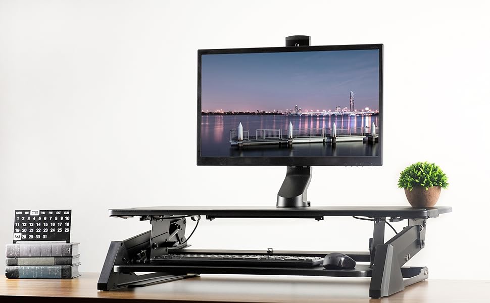 main banner monitor mount attached to height adjustable standing desk riser