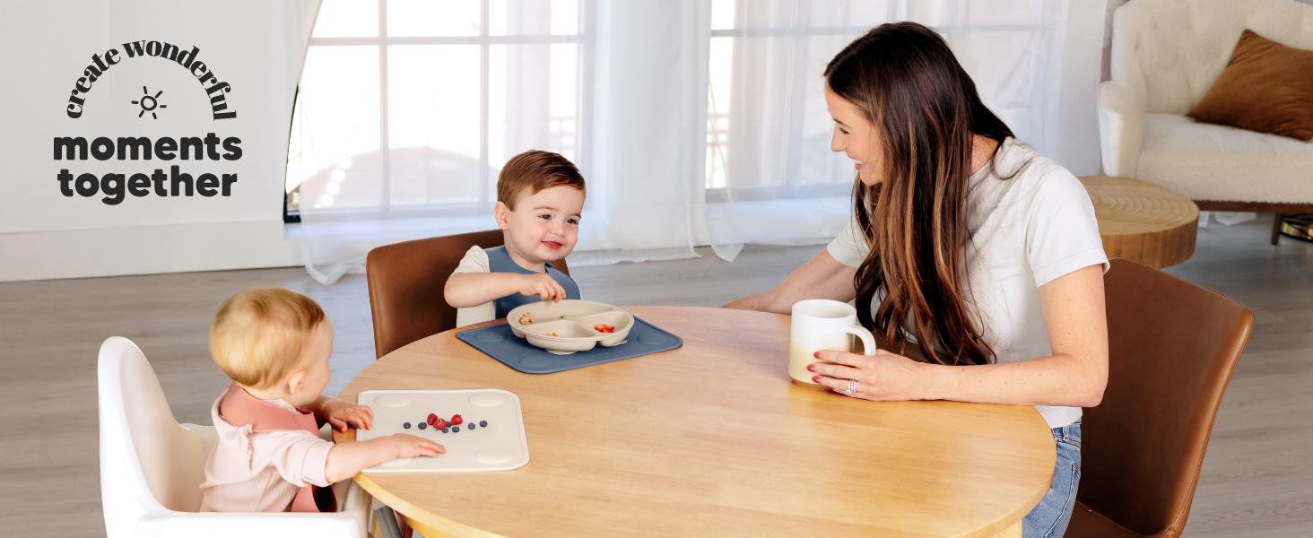 Family enjoying mealtime together with babies using Prep silicone placemats for easy feeding