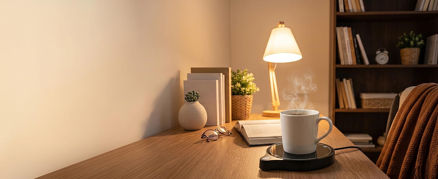 ZenthermoRui coffee mug warmer on desk with steaming mug, book and lamp in background