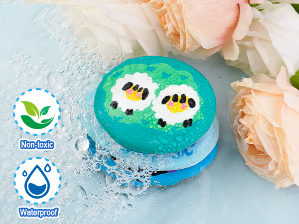 Text shows 'Non-toxic' and 'Waterproof' with icons. Turquoise bath bombs with black and white details, displayed with pink roses on watery surface.