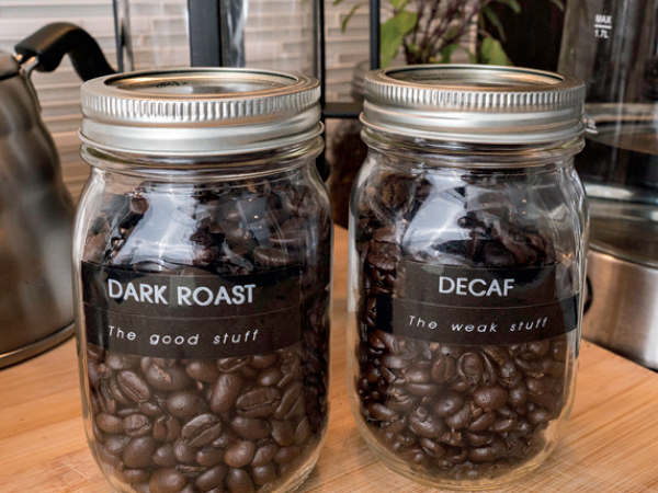 Mason jars filled with whole coffee beans, labeled "Dark Roast" and "Decaf"