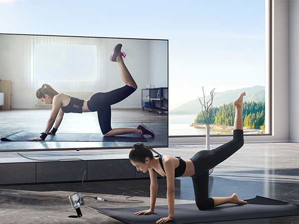 Exercise or yoga sequence showing plank and push-up positions performed on a black exercise mat in a bright, window-lit room.
