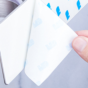 Multiple views demonstrating white foam adhesive tape strips being applied and peeled. Shows the tape's thickness and adhesive backing being revealed.