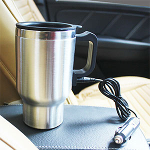 a travel mug sits on a car seat.