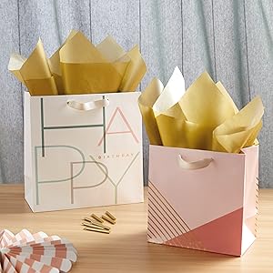 Modern birthday gift bags in blush pink, peach, sage green and light blue with gold tissue paper