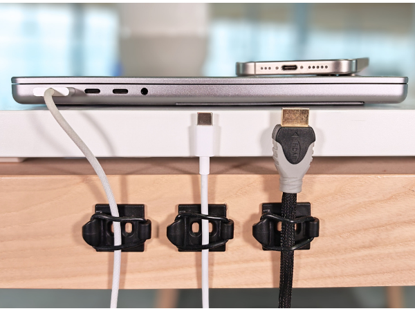 Cables secured on desk dext to laptop.