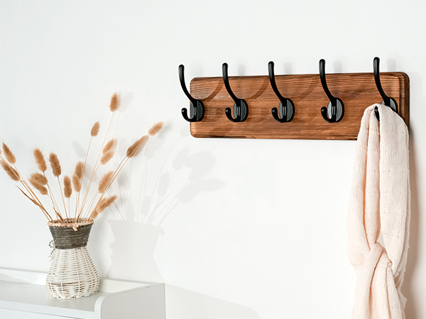 There is a weathered wooden brown wall-mounted coat rack at the entrance to the warehouse