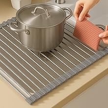 “Heat-resistant roll-up sink mat protecting countertop from hot cookware.