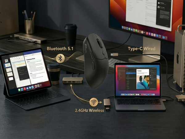Desktop setup showing multiple monitors, microphone, and computer peripherals arranged on a dark surface in a home office setting