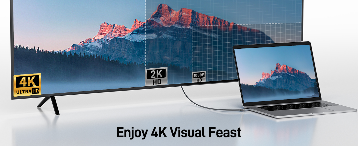 4K display setup showing laptop connected to large TV/monitor, both displaying mountain landscape scene against blue sky.
