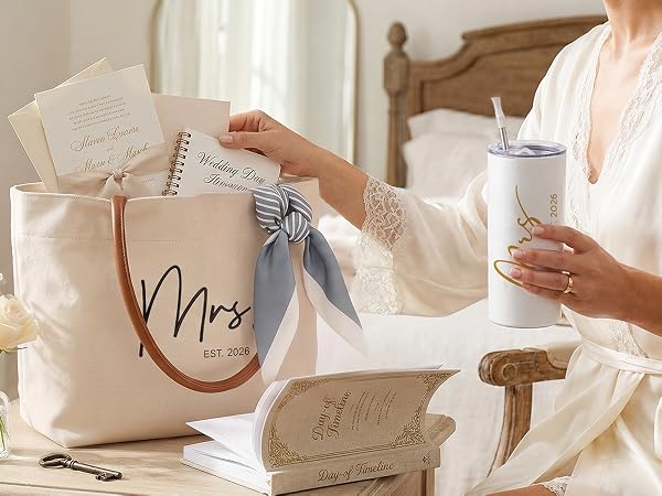 Bride in silk robe with coffee and Mrs Est 2026 tote bag containing wedding day essentials.