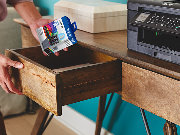 Person picking up LC401 ink cartridges from desk drawer