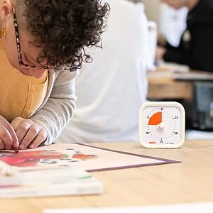Time Timer MOD 30 Minute visual timer sitting on desk while girl colors a picture.