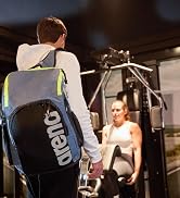 man using a gray arena Team 45 backpack at the gym great for swim practice and gym workouts