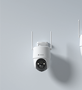 A small white cylindrical device with antennas mounted on a light-colored wall.