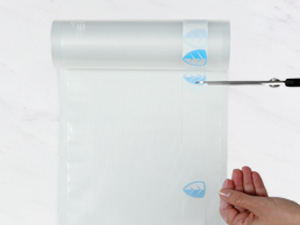 Plastic roll being cut with scissors by a hand