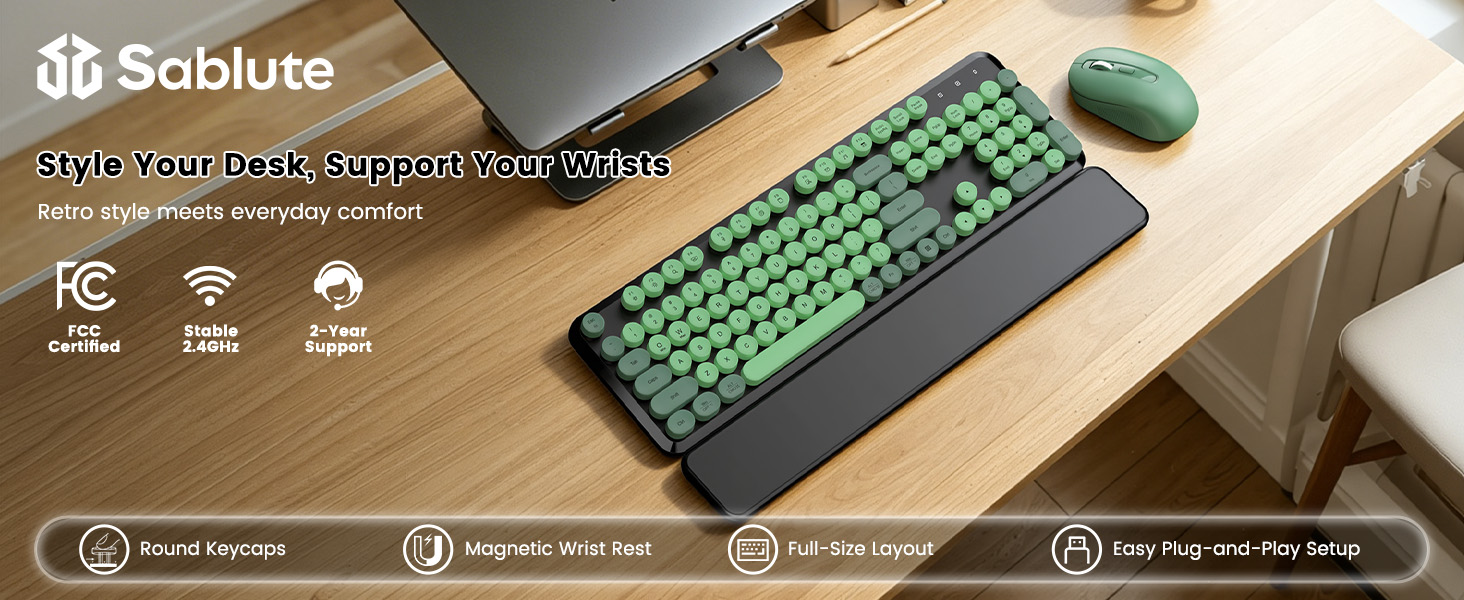 Green Black round-key keyboard and matching mouse with magnetic wrist rest on a wooden desk.
