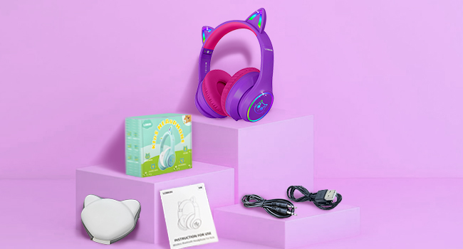 Purple cat-ear headphones displayed with accessories including a mint green card, white case, and charging cable against pink background.