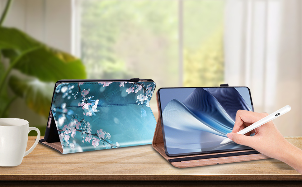 Two tablet devices on wooden surface. One displays floral wallpaper, the other shows a hand using a stylus on screen. Coffee cup nearby.