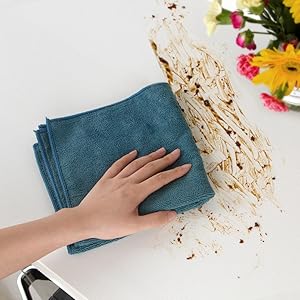 a woman's hand wiping a dirty table