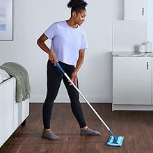 End-user using the microfiber sweeper pad to clean hardwood floors in home kitchen