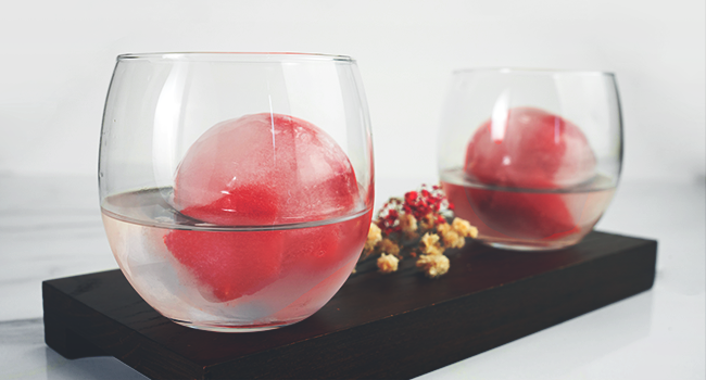 2 glasses of drink with frozen fruit ice balls made with clear ice cube maker