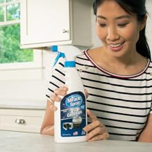 Woman holding MiracleSpray for Cooktop and Microwave