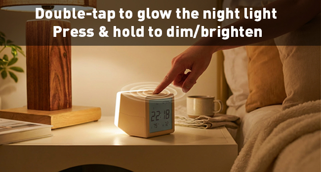 Text reads: 'Double-tap to glow the night light' and 'Press & hold to dim/brighten'. Shows demonstration of digital clock/light device on wooden surface in warm, dimly lit room setting.