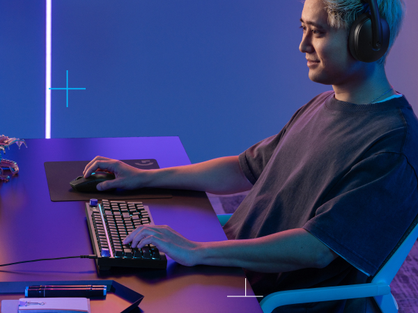 a person holding a mouse and typing on a keyboard