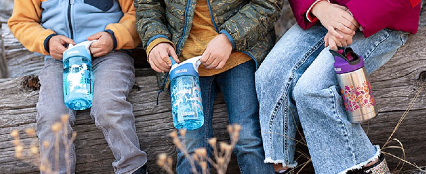 Three kids holding thrive kids water bottles