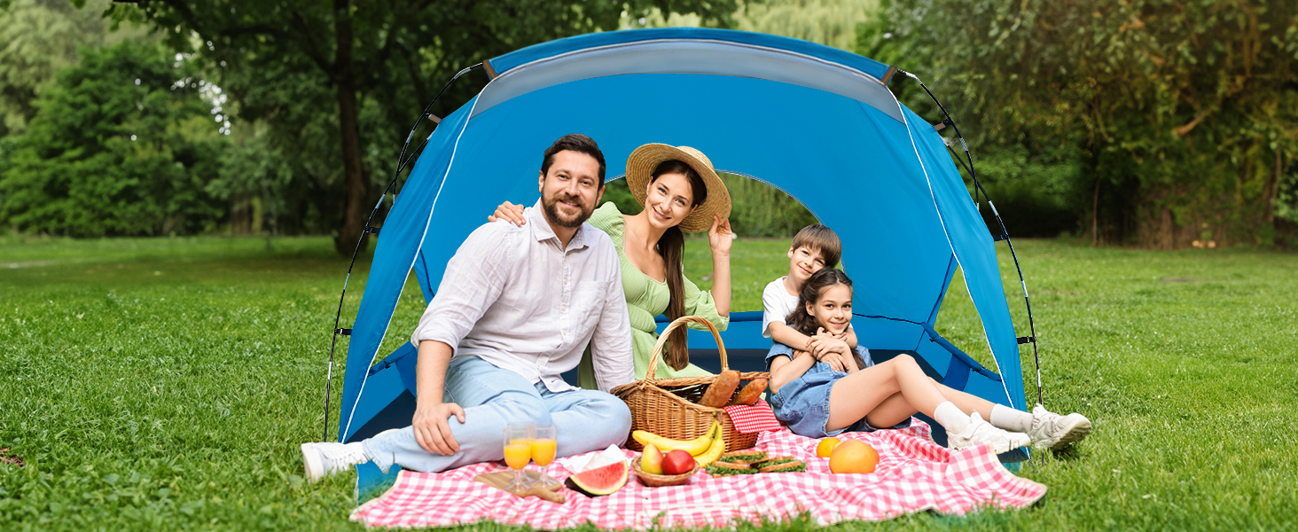 Family of four sitting in tent camping on the grass