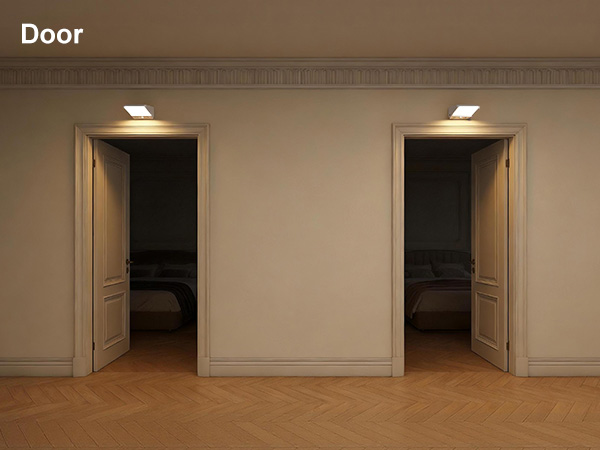 Text reads 'Door'. Two white wooden interior doors with light wood frames in a beige/cream colored wall, recessed lighting above.