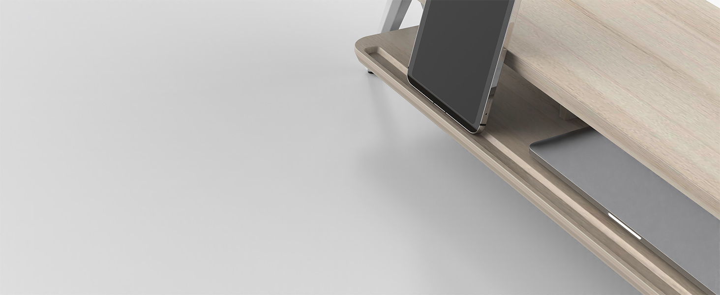 Close-up of a wooden desk with a built-in device stand. A smartphone is propped up on the stand, which is integrated into the desk's surface.
