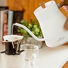 Woman touring water from kettle into pour over coffee kit