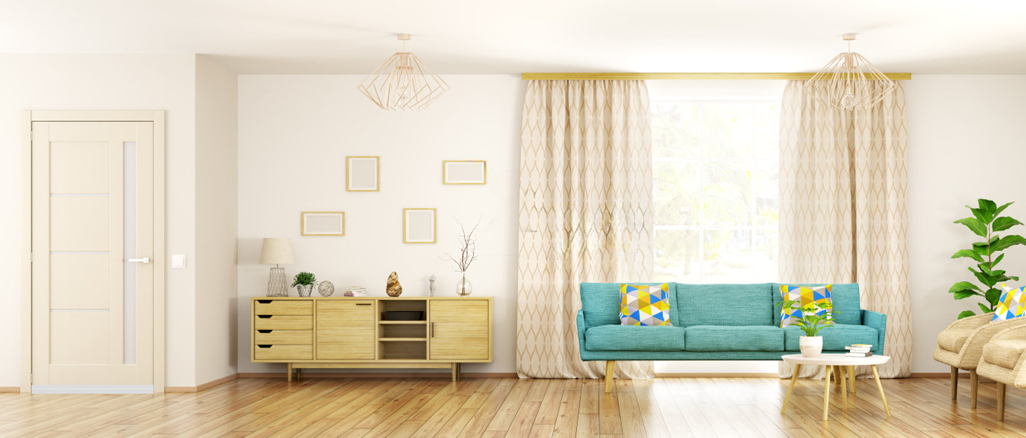 Modern living room interior with teal sofa, wooden sideboard, white walls, and floor-to-ceiling curtains in natural light.