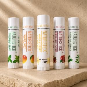 Naturistick lip balm sticks in assorted flavors on a warm stone surface