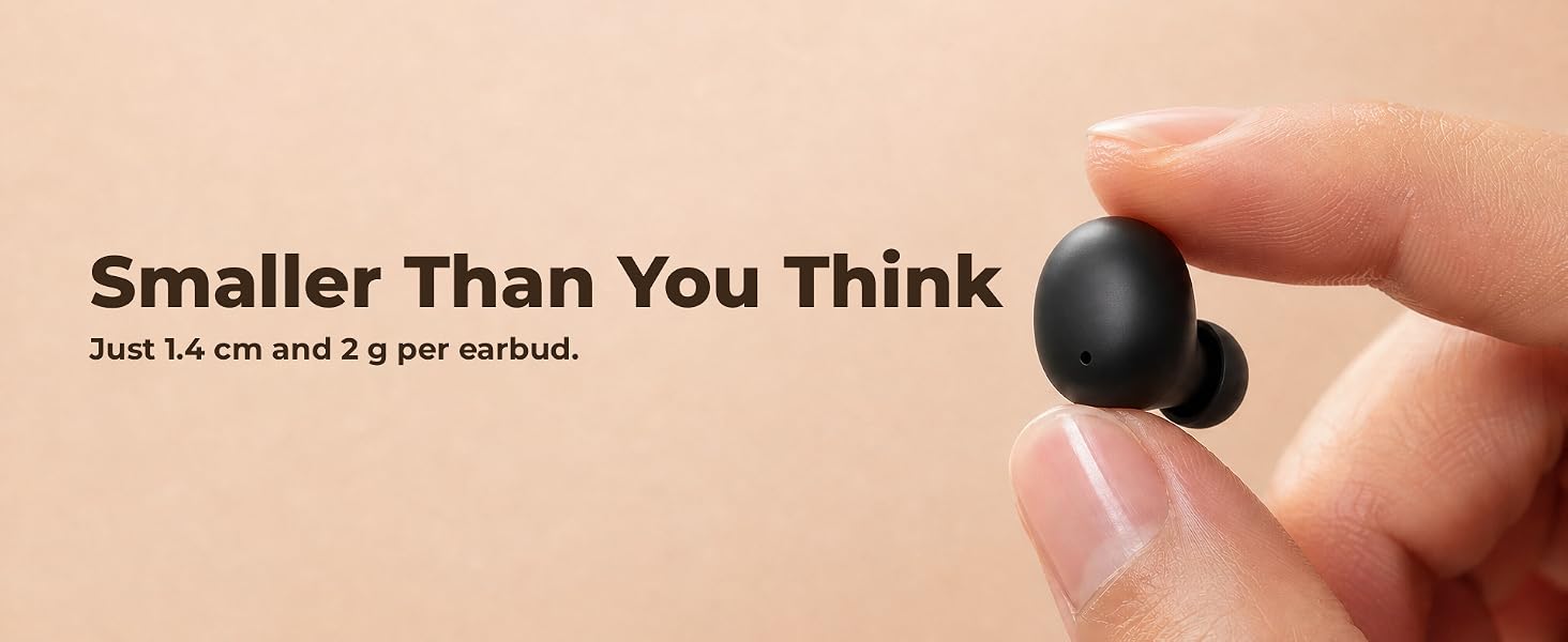 A tiny black wireless earbud held between two fingers, showing how small it is