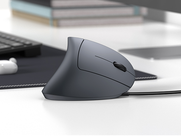 Ergonomic computer mouse in matte dark gray, featuring vertical design with curved grip and side buttons, positioned on white desk surface.