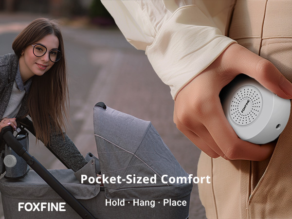 White noise machine shown in hand, hanging from stroller, showing the portable design